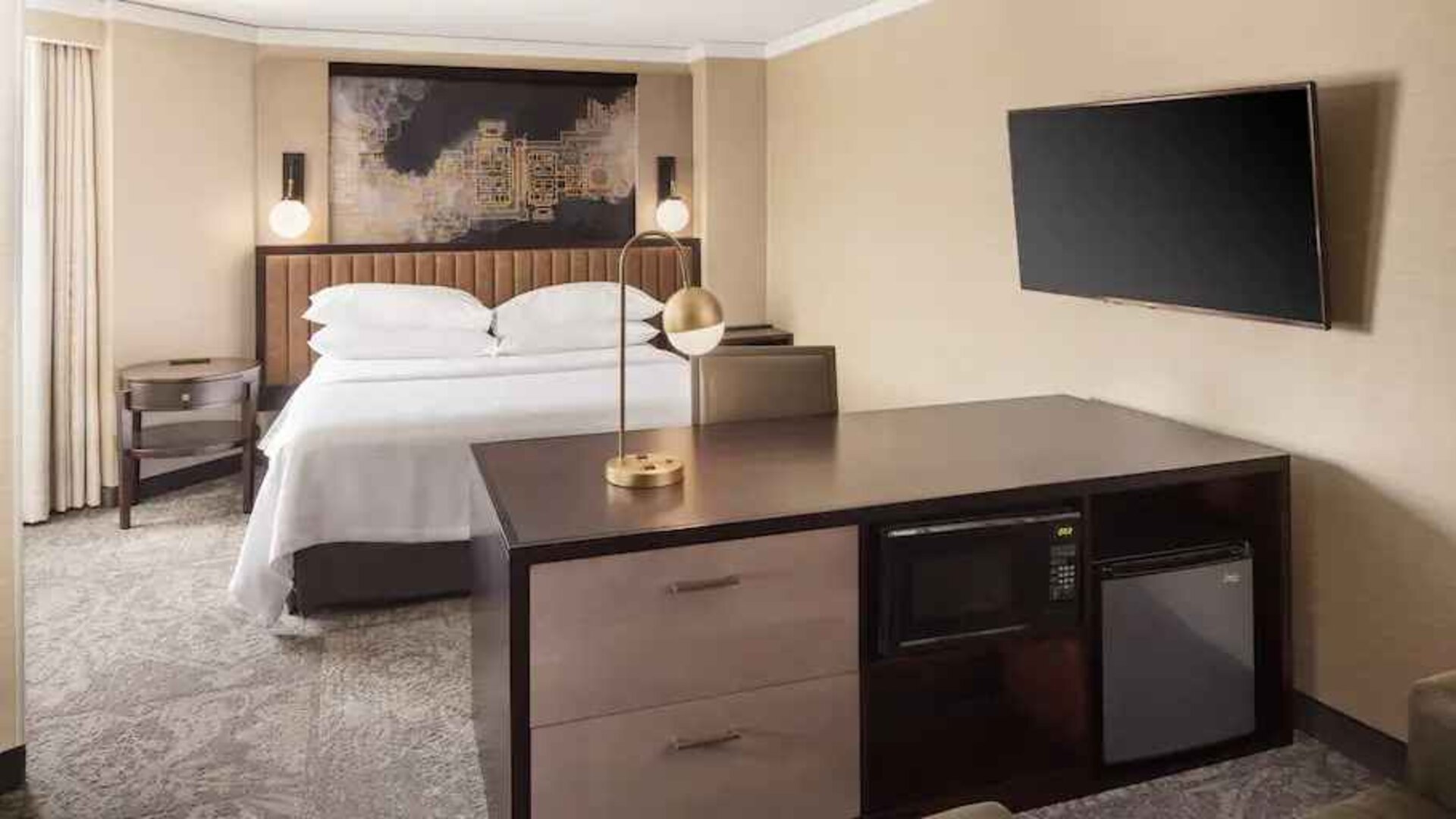 Bright king bedroom with window and TV screen at the Embassy Suites by Hilton Tysons Corner.