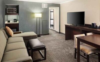 Spacious and comfortable hotel living room with sofa and desk at the Embassy Suites by Hilton Tysons Corner.