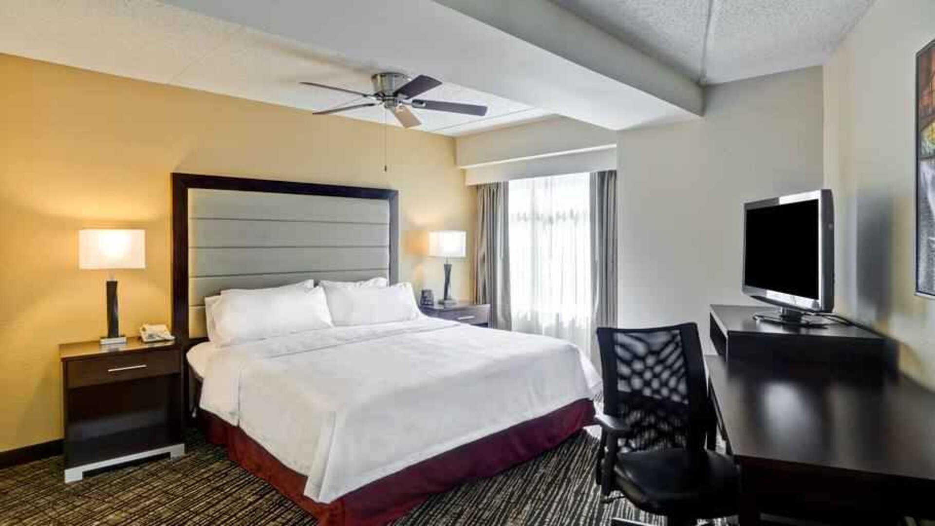King bedroom with working station and TV screen at the Homewood Suites by Hilton Washington, D.C. Downtown.