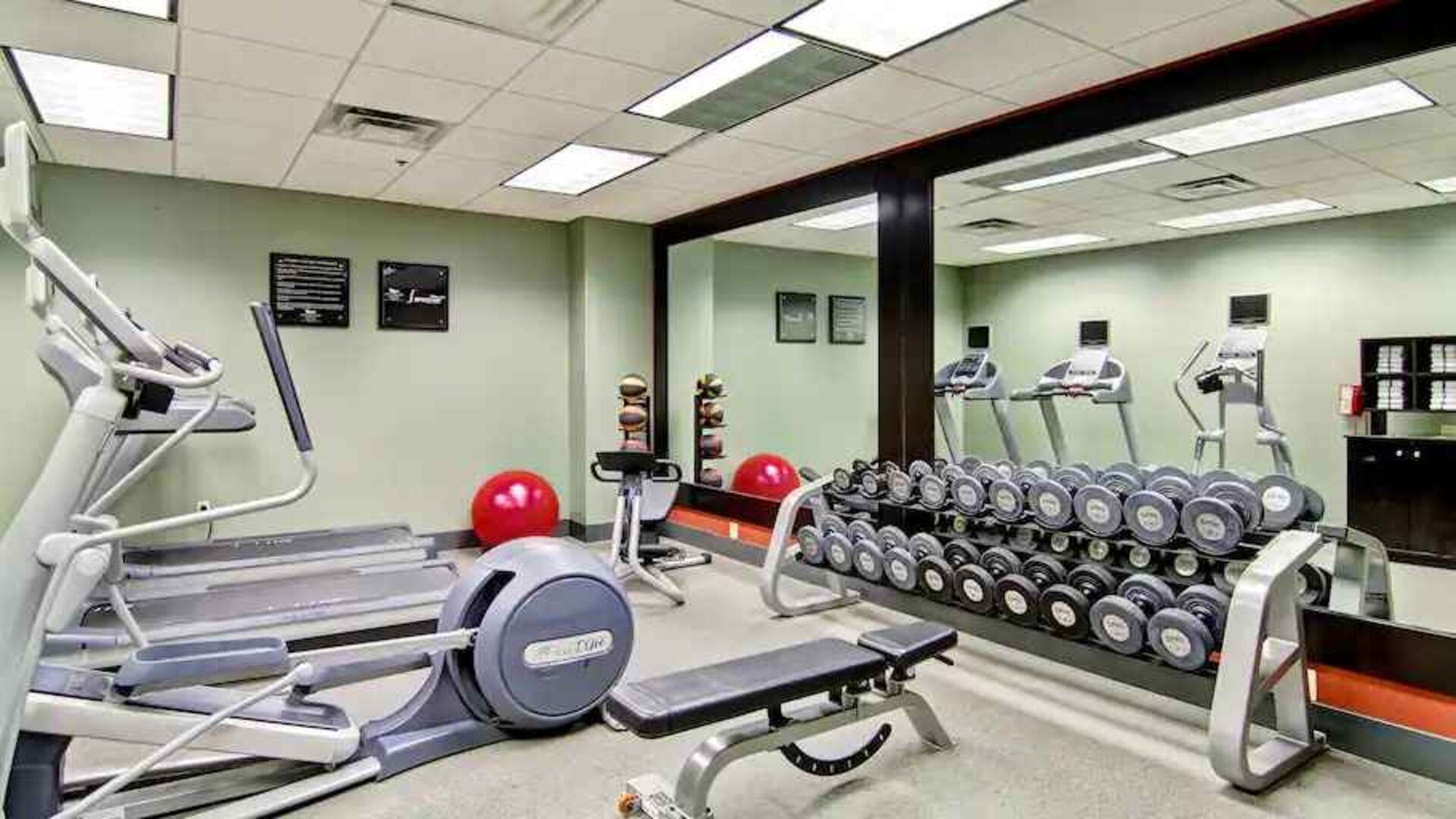 Fitness center with mirrors at the Homewood Suites by Hilton Washington, D.C. Downtown.