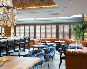 Comfortable lobby and restaurant area ideal as a coworking space at The Sam Houston, Curio Collection by Hilton.