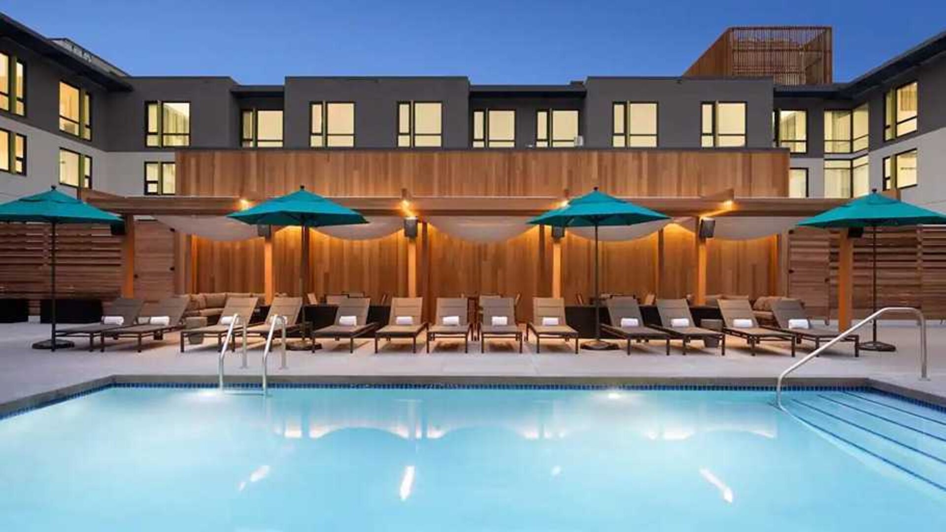 gorgeous outdoor pool with sun beds and seating area at Embassy Suites by Hilton Boulder.