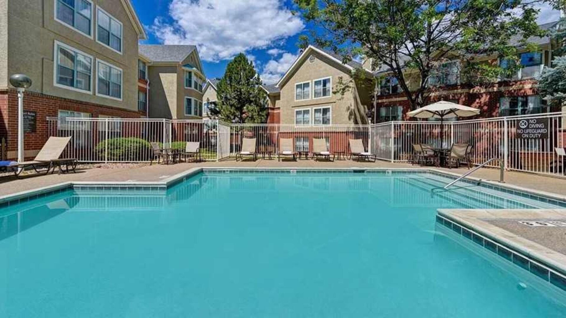 beautiful outdoor pool with sun beds and seating area at Homewood Suites by Hilton - Boulder.