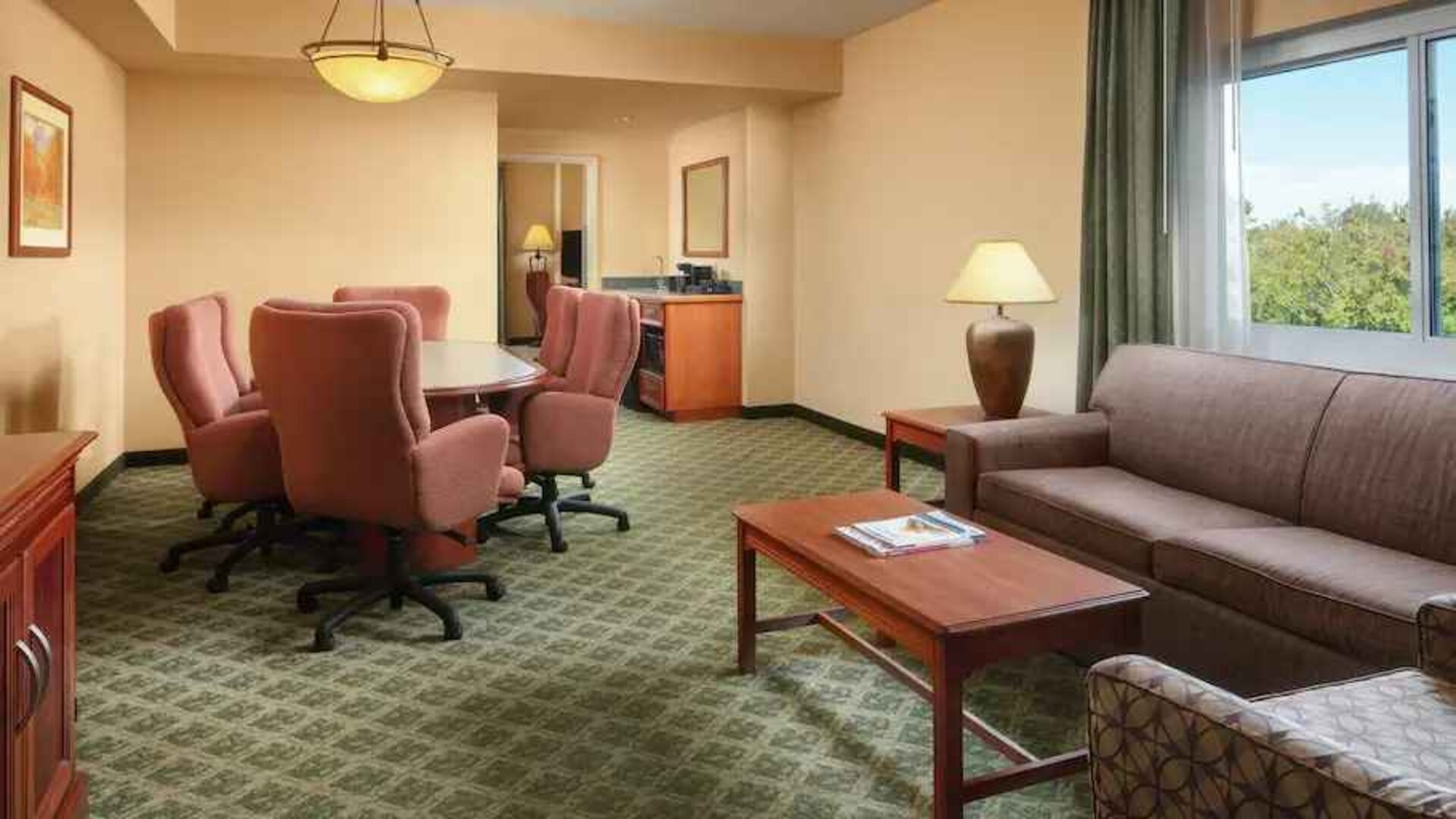 Spacious living room with working station in a hotel suite at the Embassy Suites by Hilton Charleston Airport Convention Center.