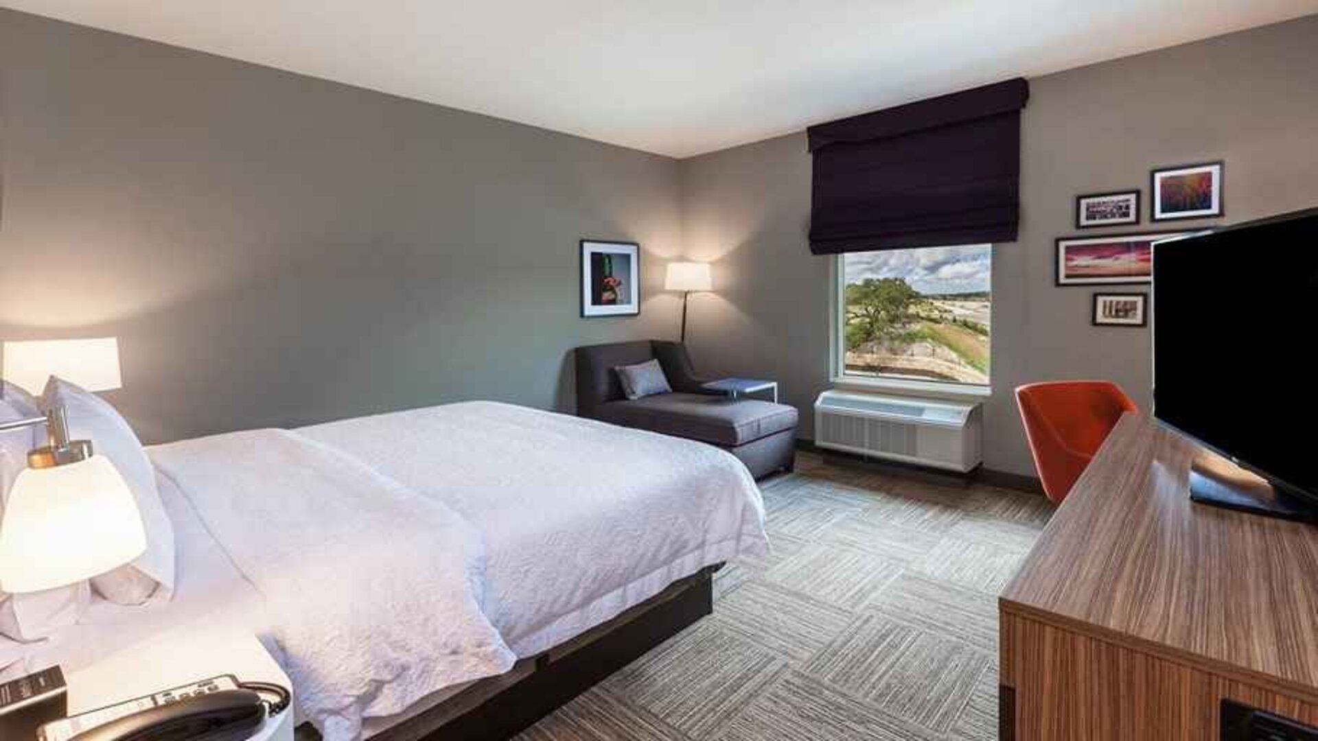 comfortable king room with TV, lounge area, and work desk ideal for working remotely at Hampton Inn Bulverde Texas Hill Country.