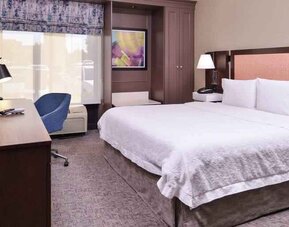 Comfortable king size bed in a hotel room at the Hampton Inn Albuquerque, University-Midtown (UNM).