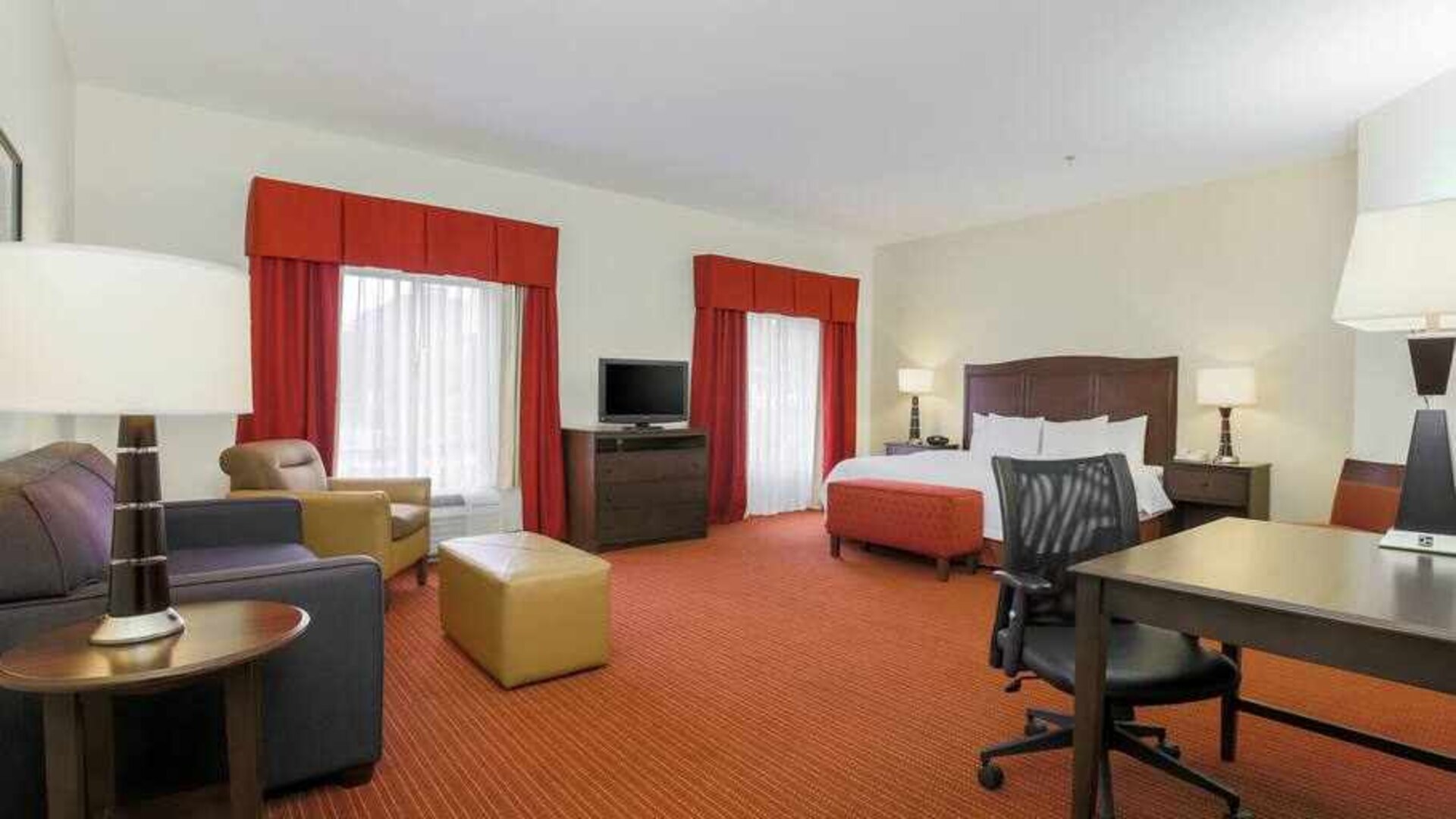 Working station with desk and sofa in a king guestroom at the Hampton Inn Champaign Urbana.