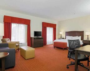 Working station with desk and sofa in a king guestroom at the Hampton Inn Champaign Urbana.