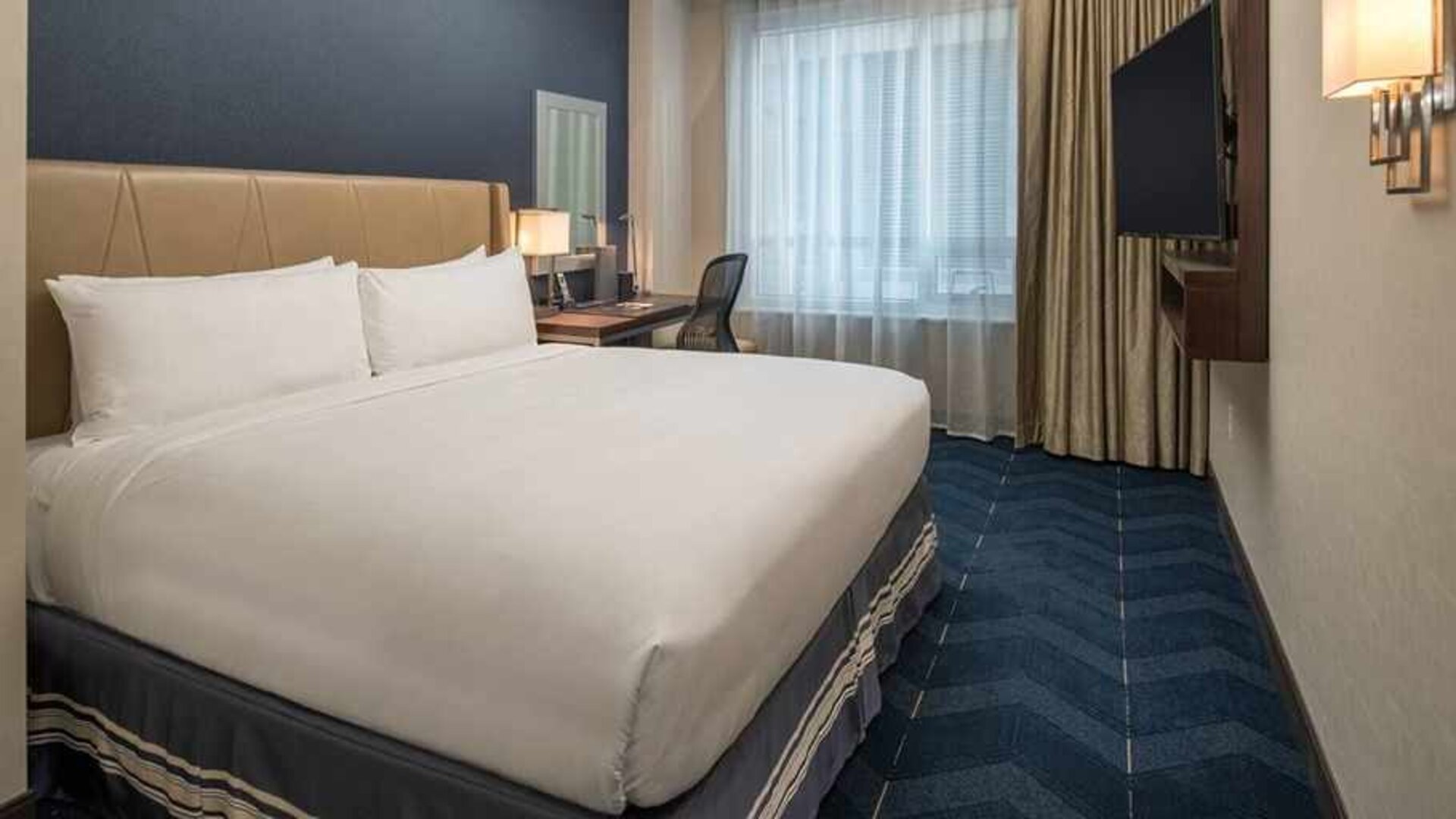 comfortable king room with TV and work desk at Embassy Suites by Hilton Seattle Downtown Pioneer Square.