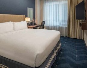 comfortable king room with TV and work desk at Embassy Suites by Hilton Seattle Downtown Pioneer Square.