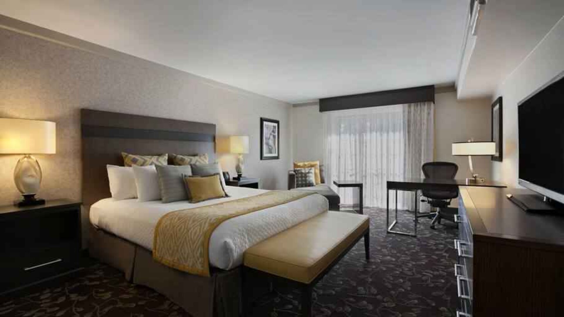 Presidential suite with king size bed and desk at the Embassy Suites by Hilton Napa Valley.