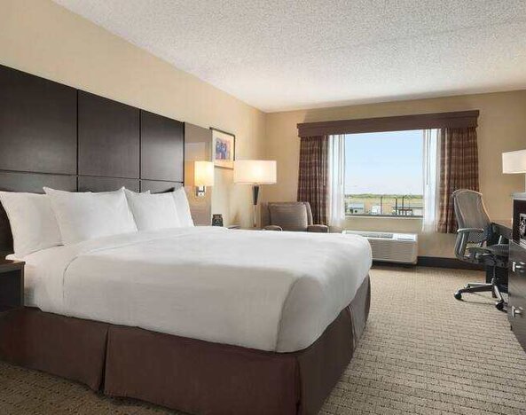 Bright king bedroom with window at the DoubleTree by Hilton Wichita Airport.