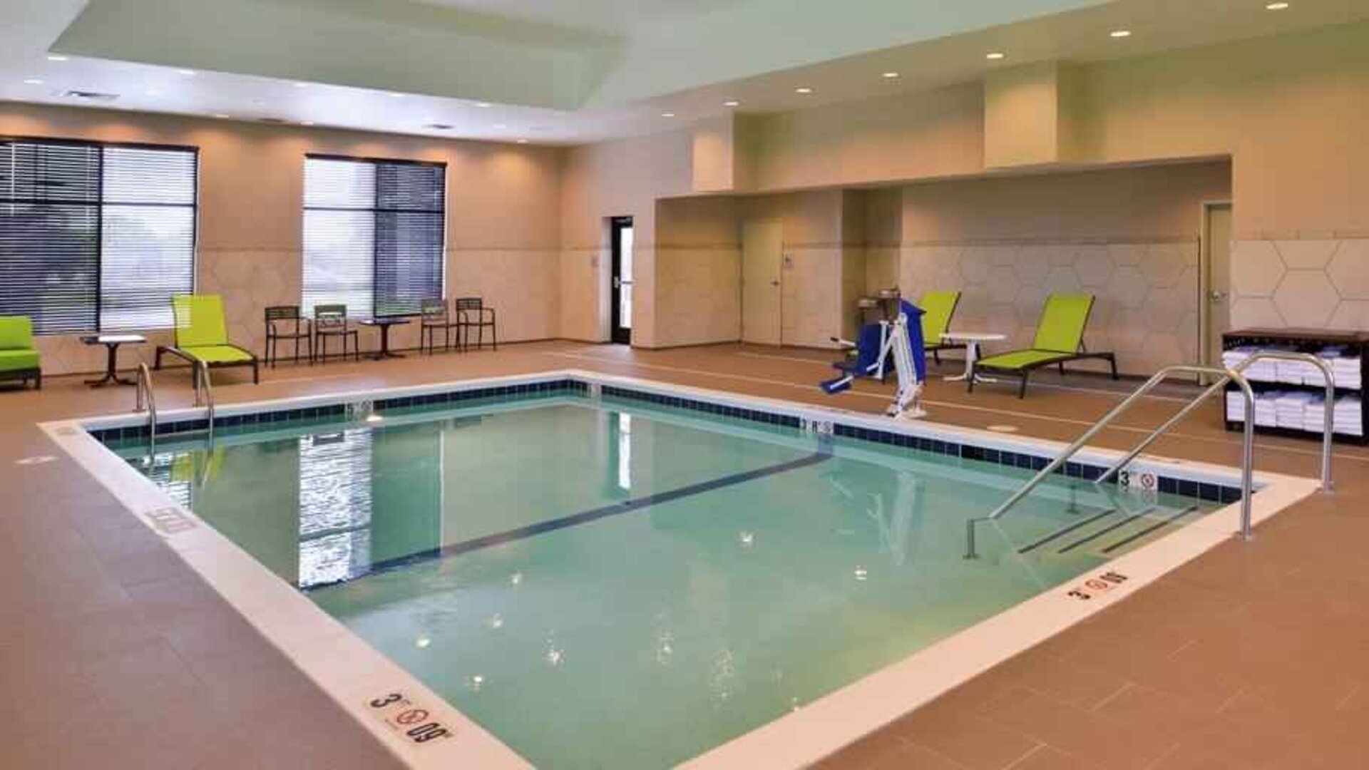 Indoor pool area with lounges and chairs at the Hampton Inn & Suites St. Paul Oakdale/Woodbury by Hilton.