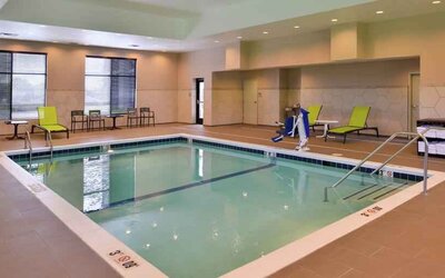 Indoor pool area with lounges and chairs at the Hampton Inn & Suites St. Paul Oakdale/Woodbury by Hilton.
