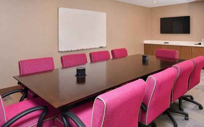 Small meeting room with pink chairs at the Hampton Inn & Suites St. Paul Oakdale/Woodbury by Hilton.