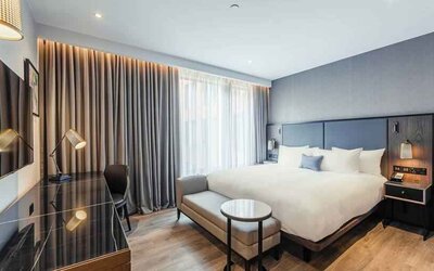 Bright king bedroom with desk at the Fellows House Cambridge, Curio Collection by Hilton.