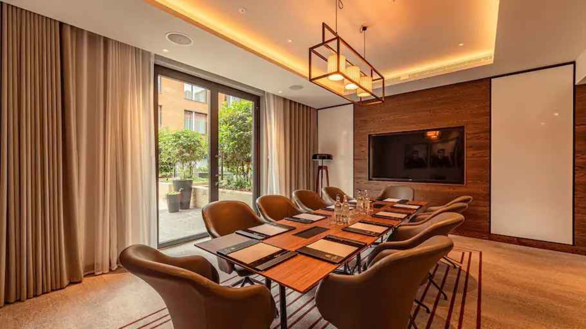 Small meeting room with TV screen at the Fellows House Cambridge, Curio Collection by Hilton.