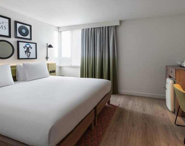 Bright king guestroom with desk at the Hampton by Hilton London Ealing.