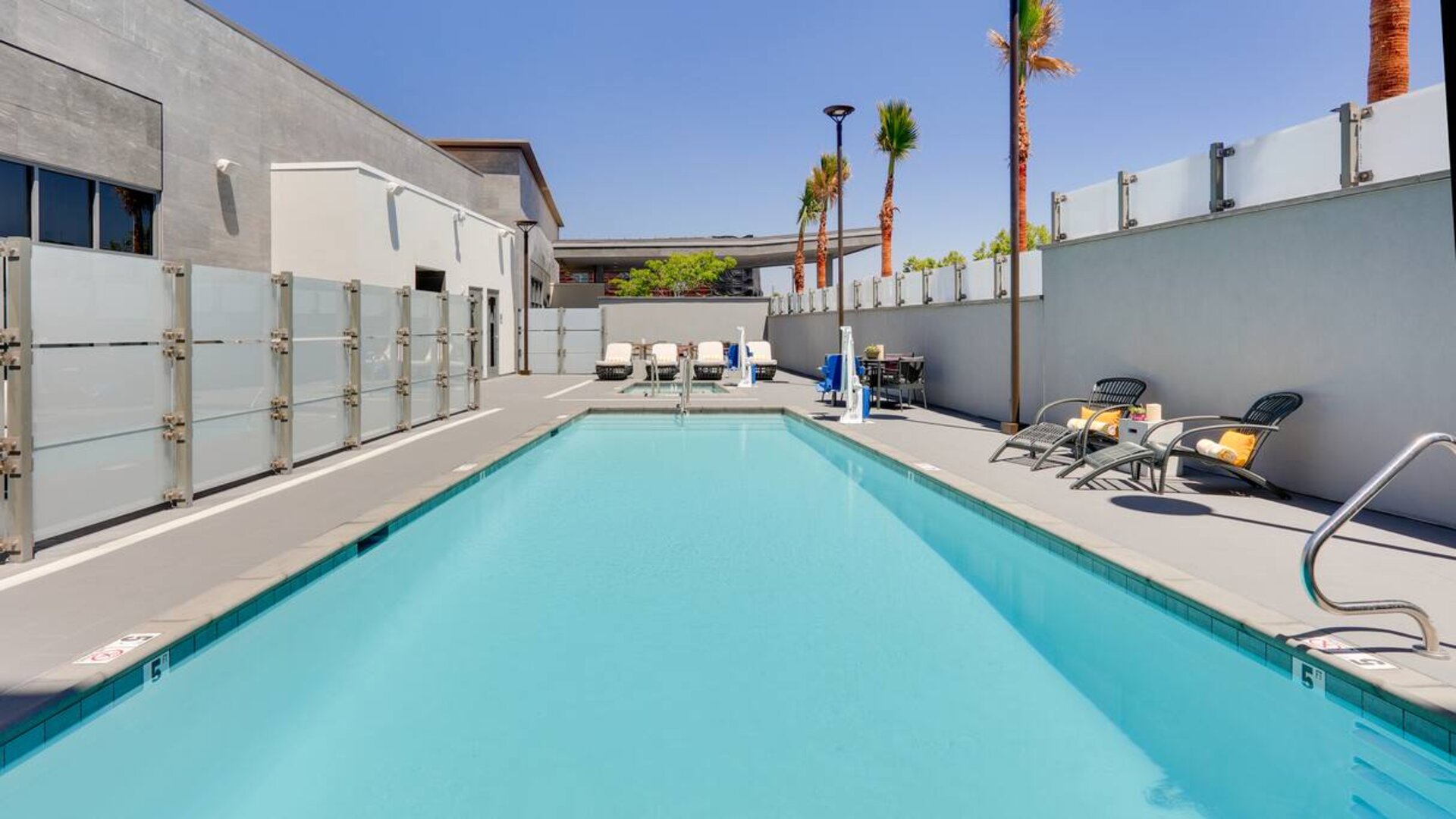 large outdoor pool with sunbeds and outdoor seating at Hampton Inn Irvine Spectrum Lake Forest.