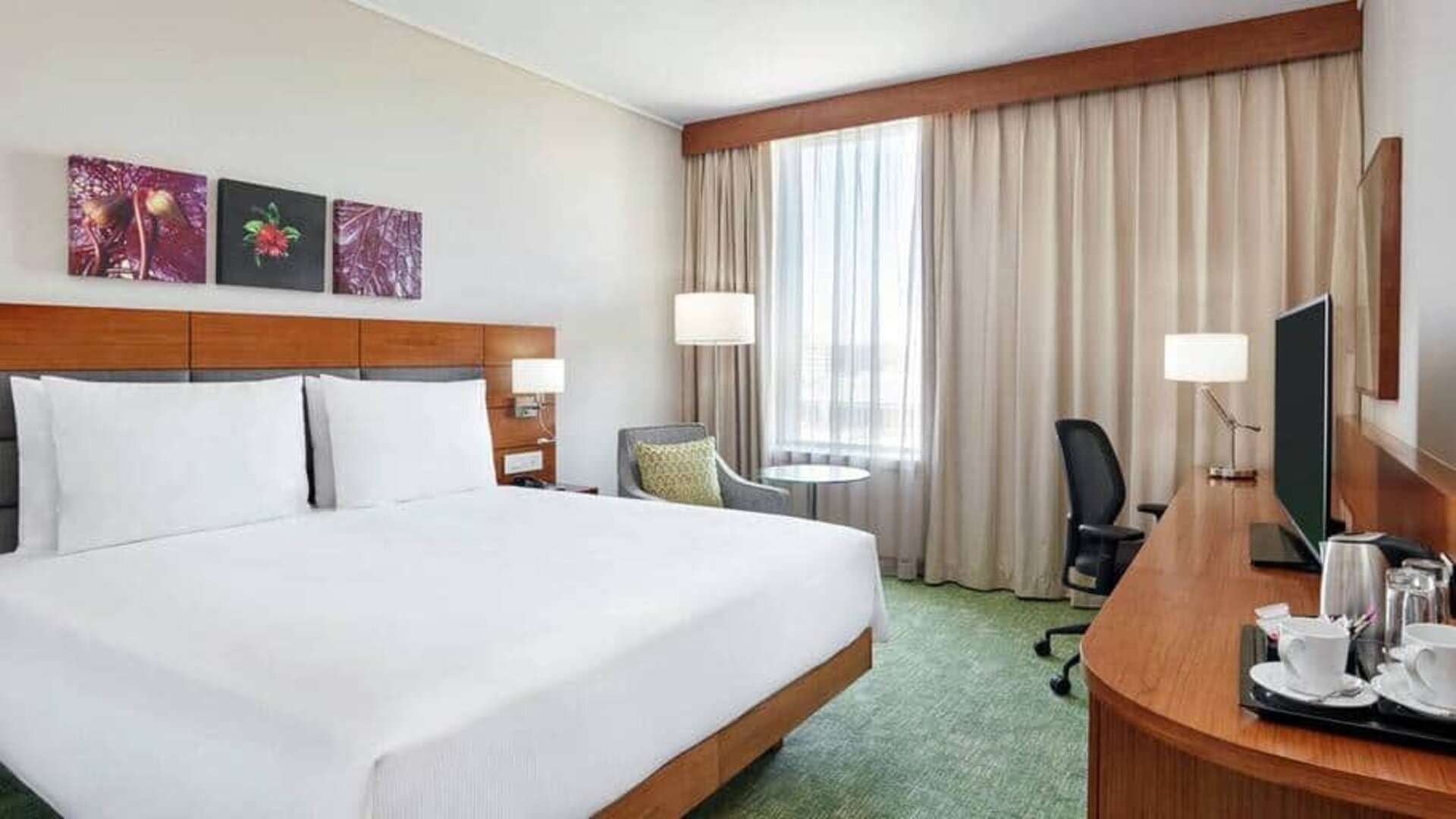 King-size bed with large desk area to work, dresser with large televsion on top.