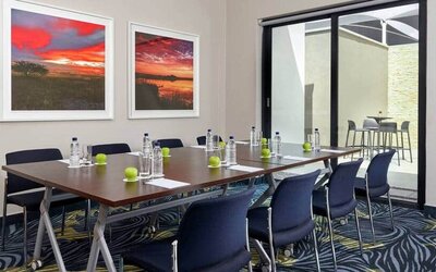 Small meeting room with rectangular table and seating for 8 guests.