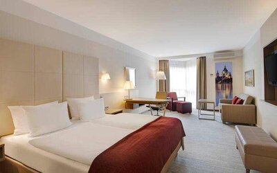 King bedroom with desk, sofa and TV screen at the DoubleTree by Hilton Hannover Schweizerhof.