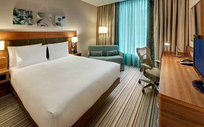 Queen room with desk and sofa at the Hilton Garden Inn Frankfurt Airport.