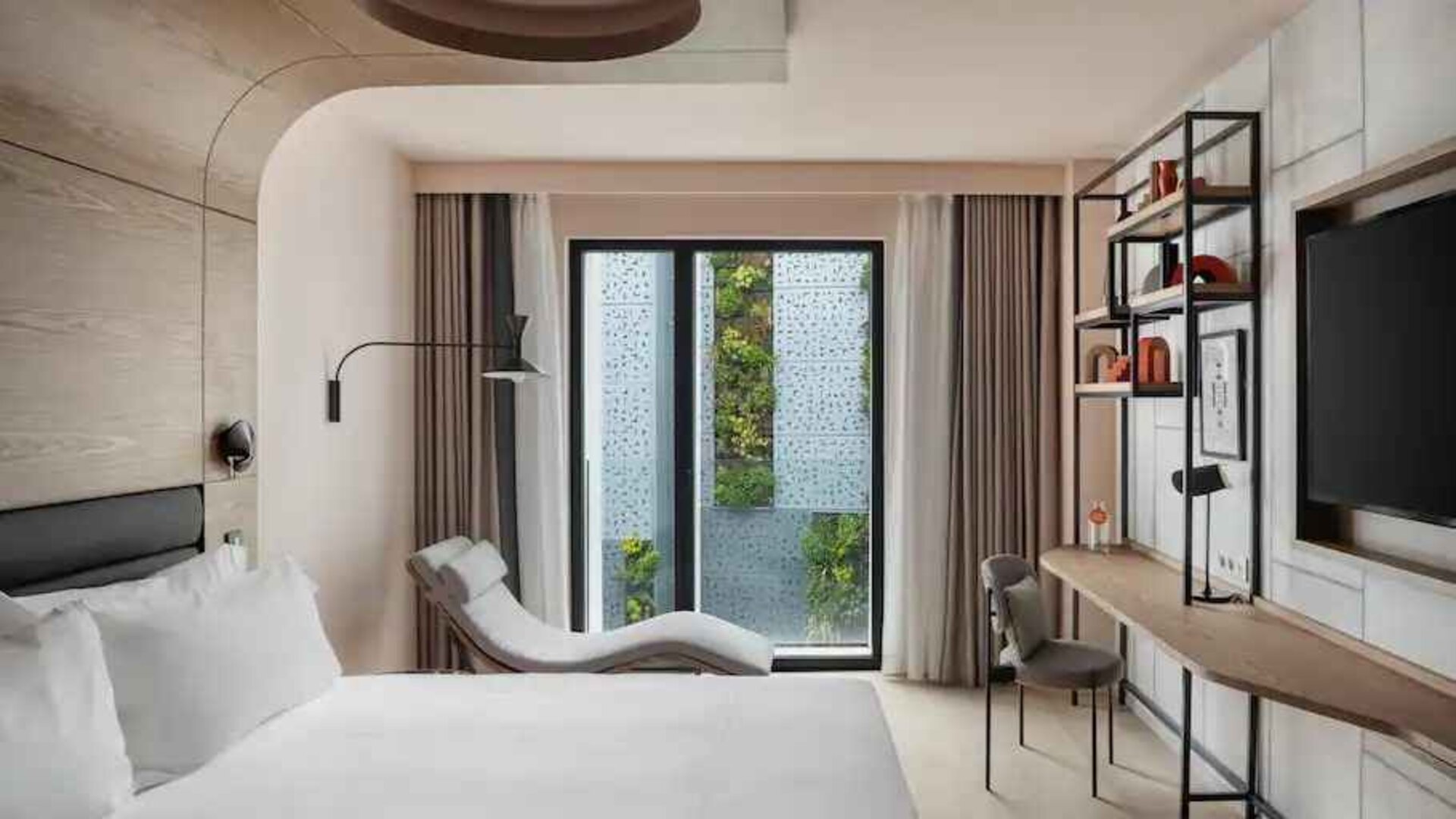 King guestroom with lounge and desk at the Canopy by Hilton Paris Trocadero.