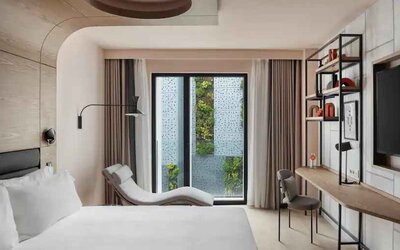 King guestroom with lounge and desk at the Canopy by Hilton Paris Trocadero.