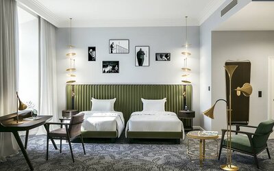 Bright twin room with desk and chairs at the Hotel Saski Krakow Curio Collection by Hilton.