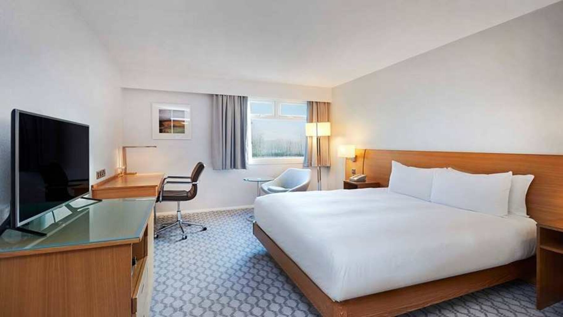 Comfortable king room with TV and work desk at Hilton London Watford.