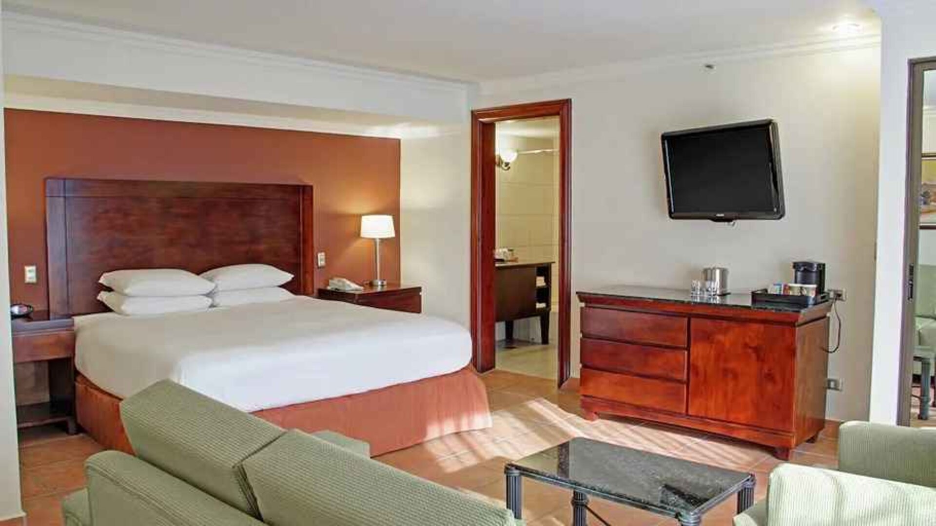 luxurious king suite with TV, work desk, and lounge area at DoubleTree by Hilton Hotel Cariari San Jose - Costa Rica.