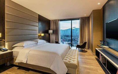luxurious king room with TV, lounge area, and lots of natural light at Hilton Bogota Corferias.