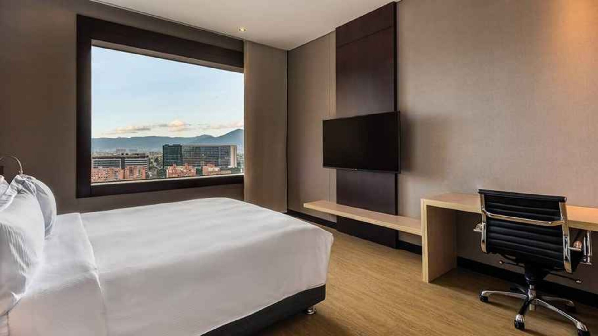 comfortable king room with TV, work desk, and natural light at DoubleTree by Hilton Bogota Salitre AR.