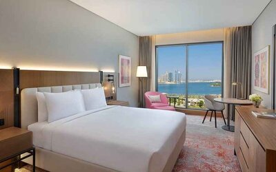 beautiful king room with work desk, TV, and water/city views at DoubleTree by Hilton Sharjah Waterfront Hotel & Residences.
