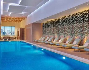 gorgeous indoor pool with pool beds at DoubleTree by Hilton Sharjah Waterfront Hotel & Residences.