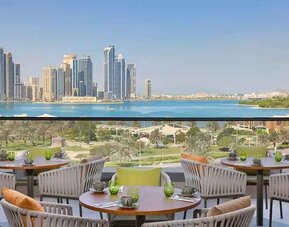 lovely outdoor terrace with gorgeous water/city views ideal as a coworking space at DoubleTree by Hilton Sharjah Waterfront Hotel & Residences.
