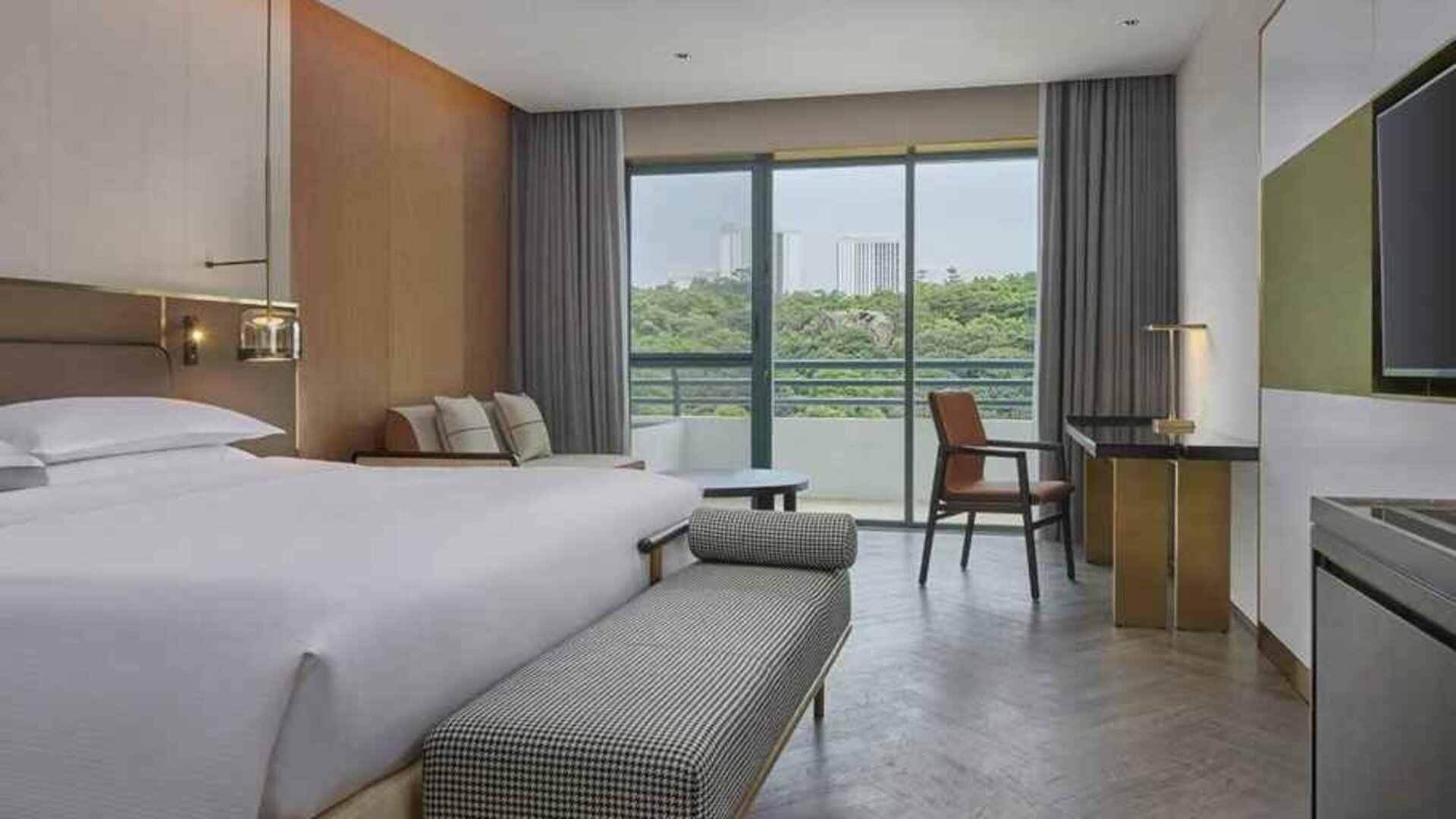 spacious king bedroom with desk, chair, and lounge suite at Hilton Guangzhou Science City.
