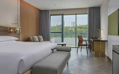 spacious king bedroom with desk, chair, and lounge suite at Hilton Guangzhou Science City.