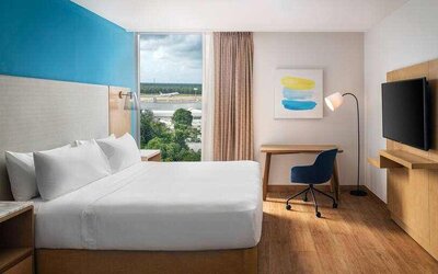 King bedroom with desk and TV screen at the Hilton Garden Inn Cancun Airport.