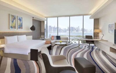 King suite with desk, sofa and TV screen at the DoubleTree by Hilton Doha - Old Town.