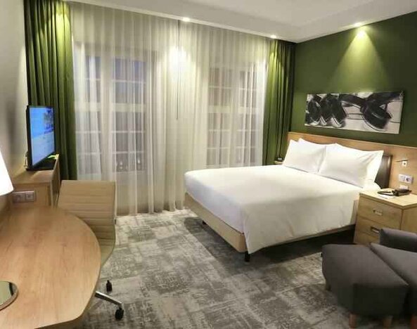 Queen room with desk and sofa at the Hampton by Hilton Gdansk Old Town.