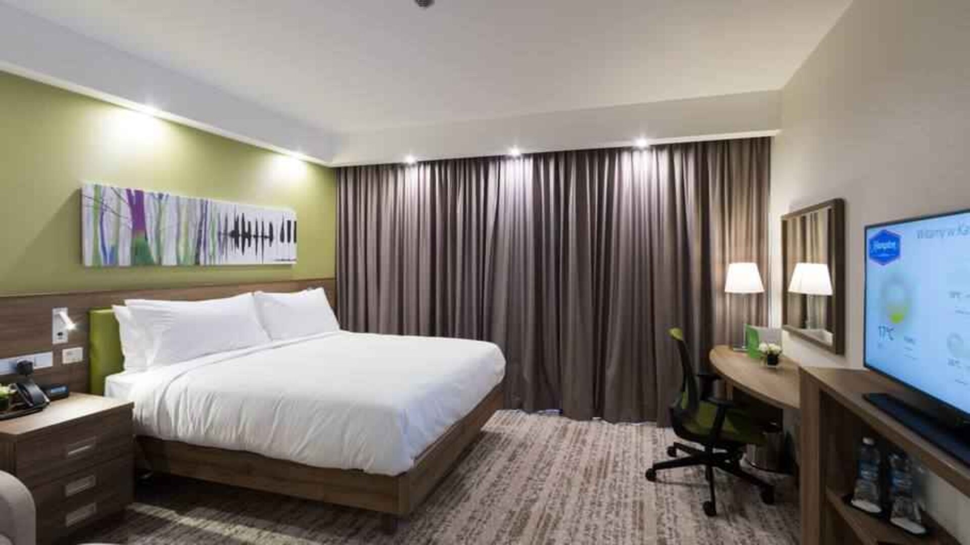 King bedroom with TV screen and desk at the Hampton by Hilton Kalisz.