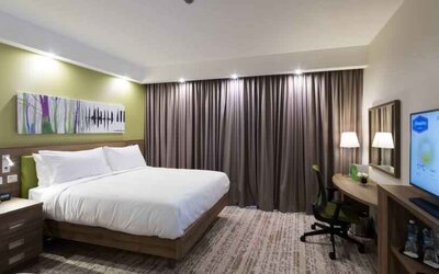 King bedroom with TV screen and desk at the Hampton by Hilton Kalisz.