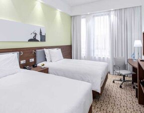 Twin room with TV screen and working station at the Hampton by Hilton Gdansk Oliwa.