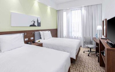 Twin room with TV screen and working station at the Hampton by Hilton Gdansk Oliwa.