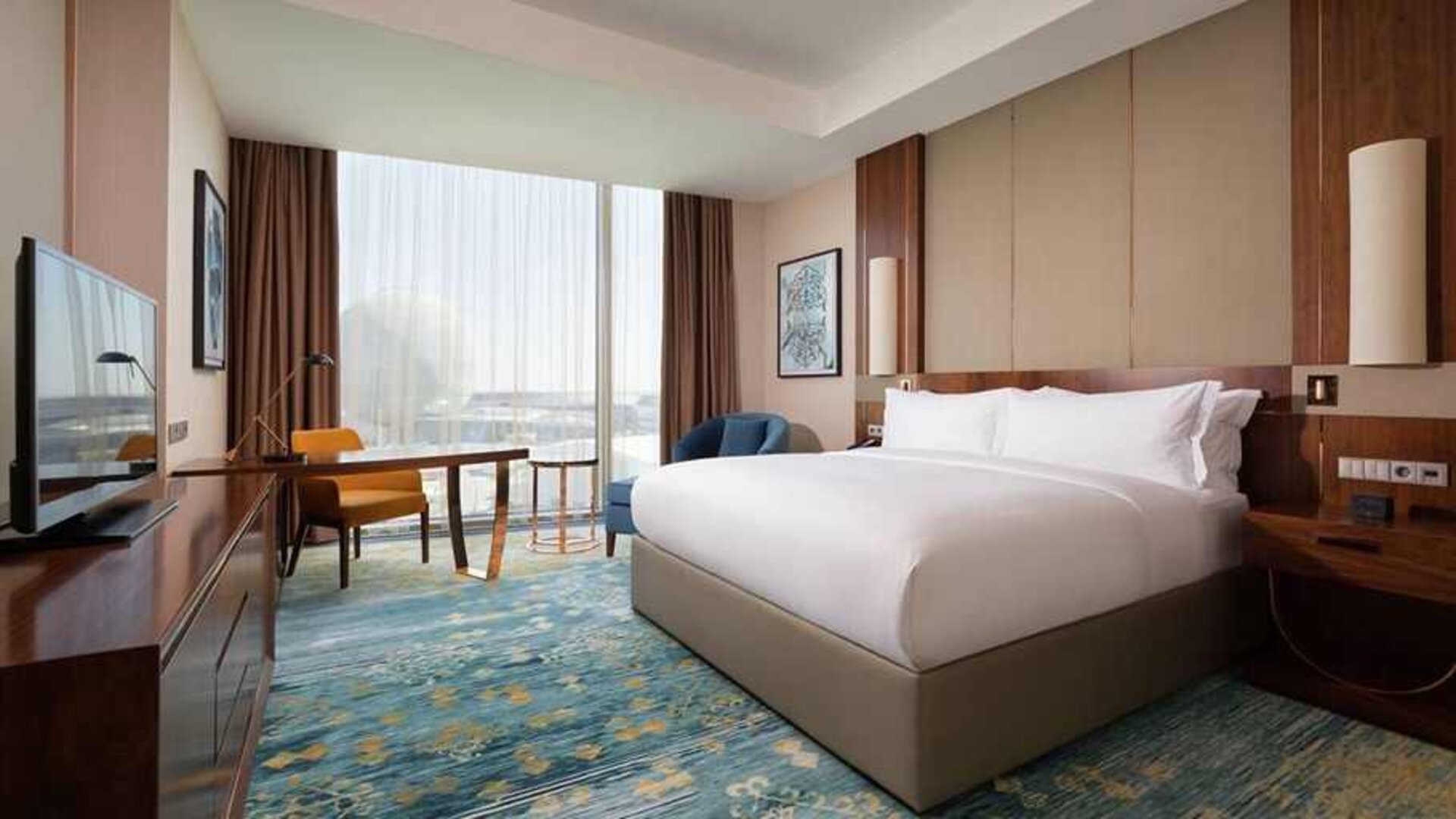 spacious king room with business desk, chair, TV, and couch at Hilton Astana.