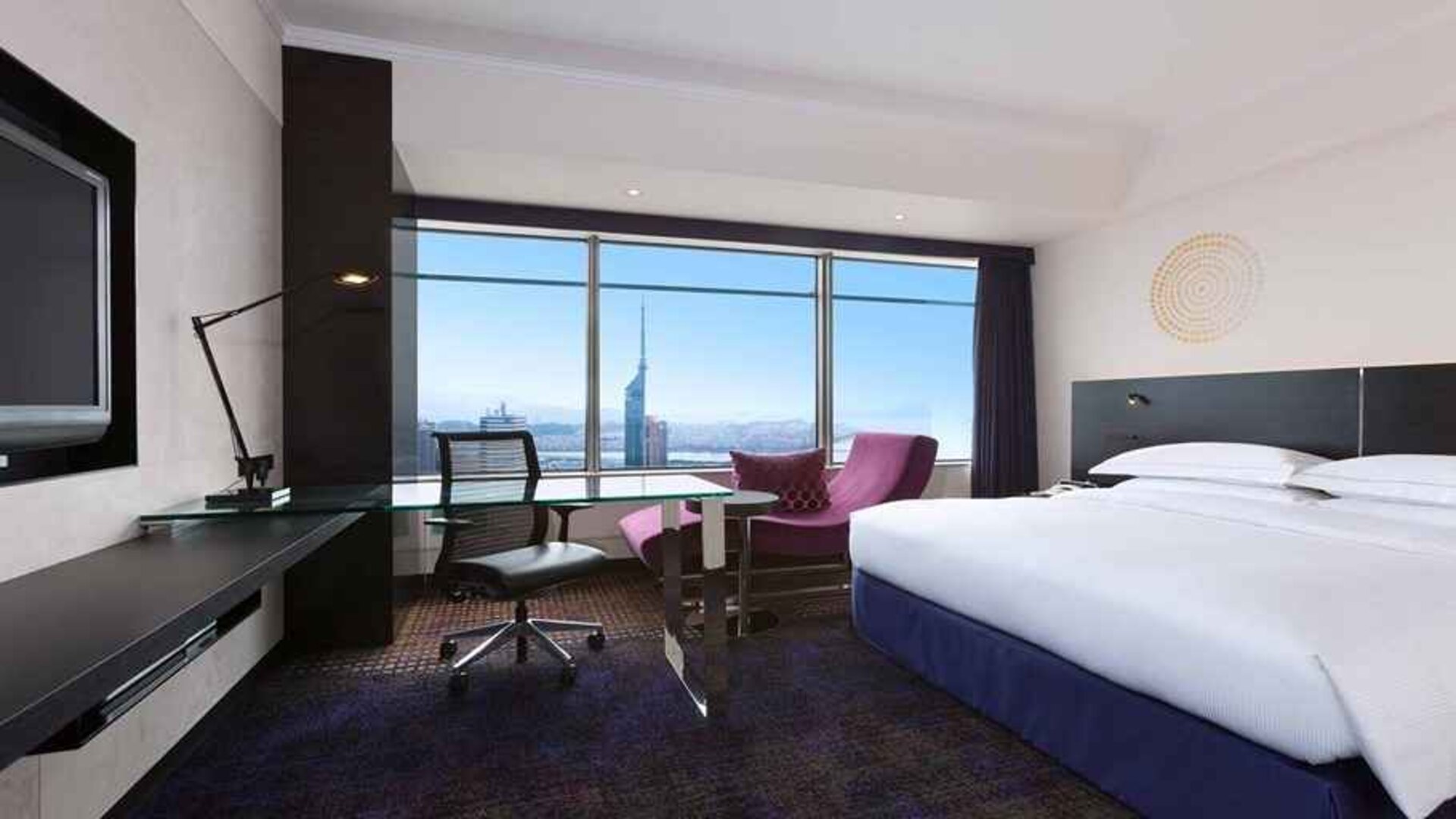 spacious king room with TV, work desk, chair, and couch at Hilton Fukuoka Sea Hawk.