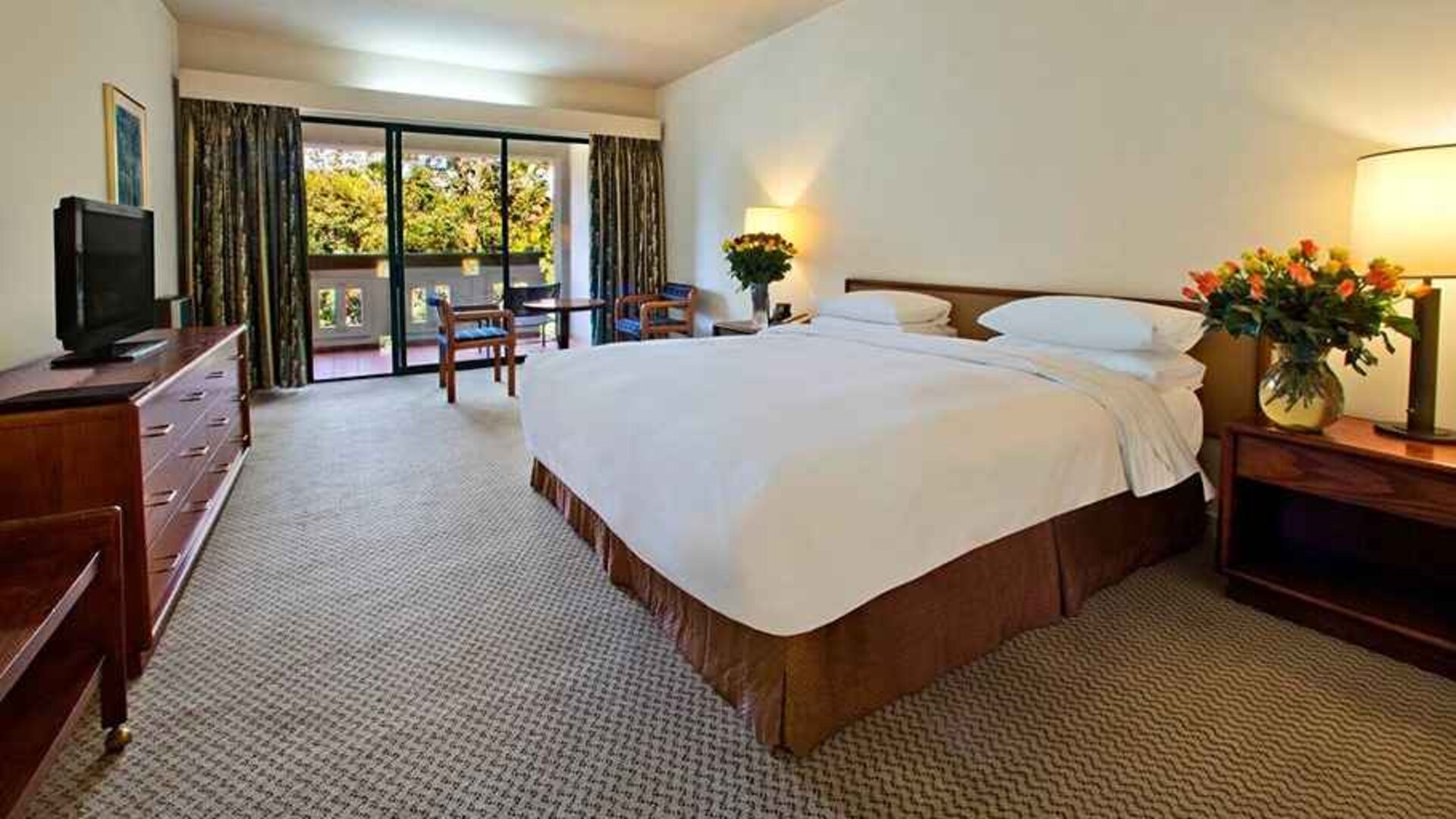 lovely king bedroom with TV and outdoor terrace at Hilton Addis Ababa.