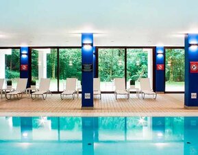 indoor pool with surrounding sunbeds at DoubleTree by Hilton Luxembourg.